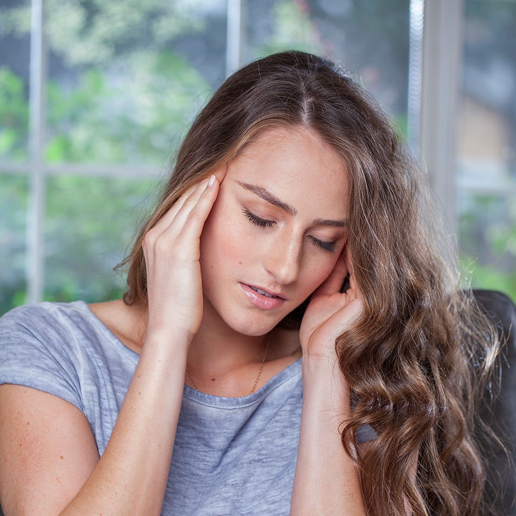Tinnitus nainen pitelee korviaan