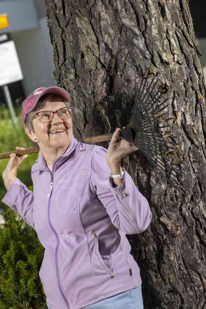 Osteoporoosia sairastava Liisa Siltanen nojaa puuhun